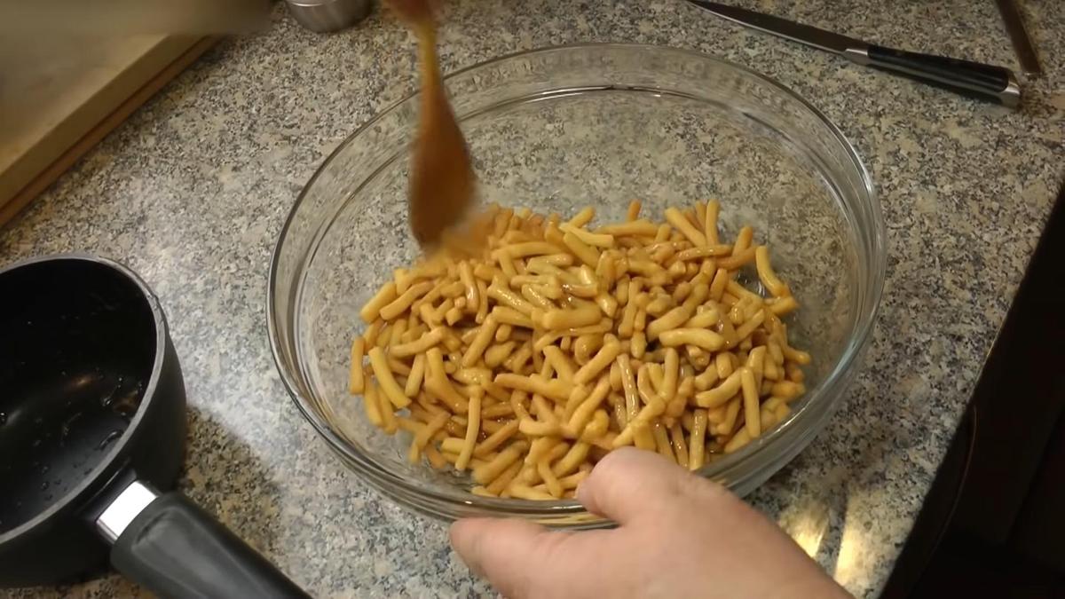 Чак-чак перемешивают деревянной ложкой в стеклянной миске