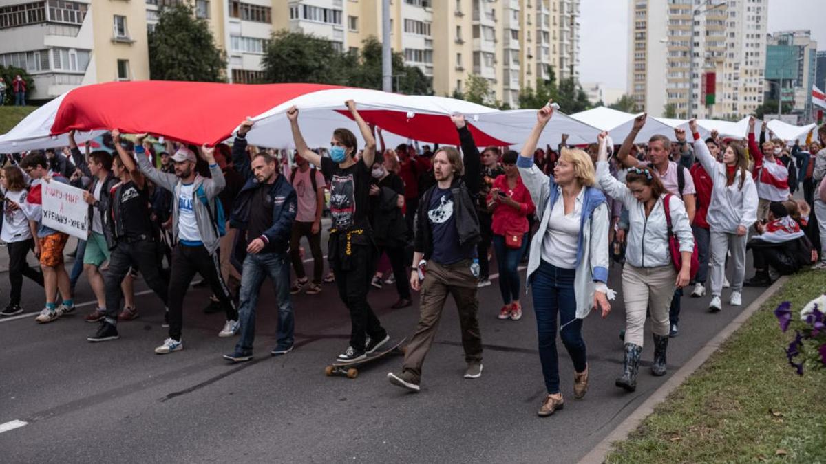 Толпа протестующих идет по улице