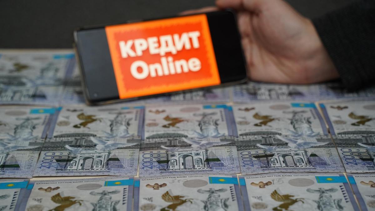 Мужчина держит в руках смартфон с надписью "Кредит Online"