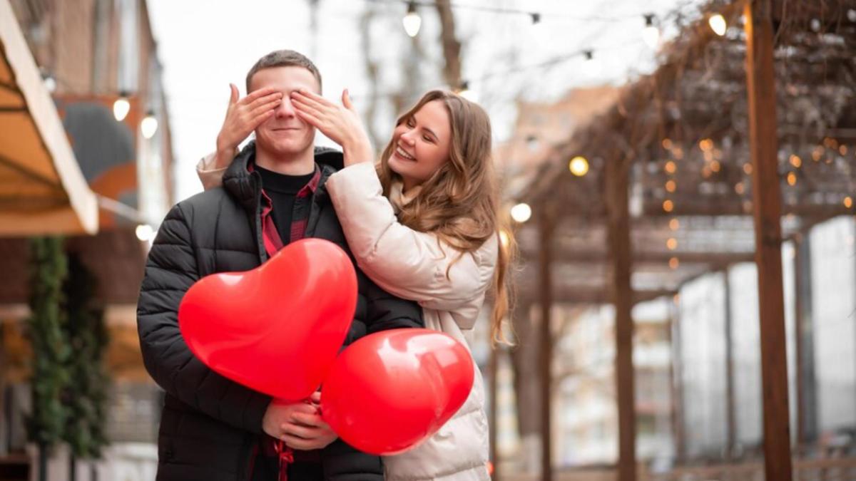 Влюбленная пара с воздушными шарами в форме сердец