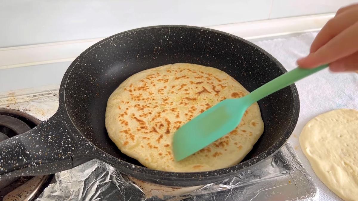 На сухой сковороде жарят лепешку