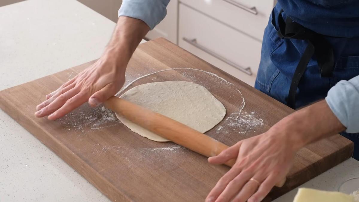 Тесто раскатывают скалкой на посыпанной мукой поверхности