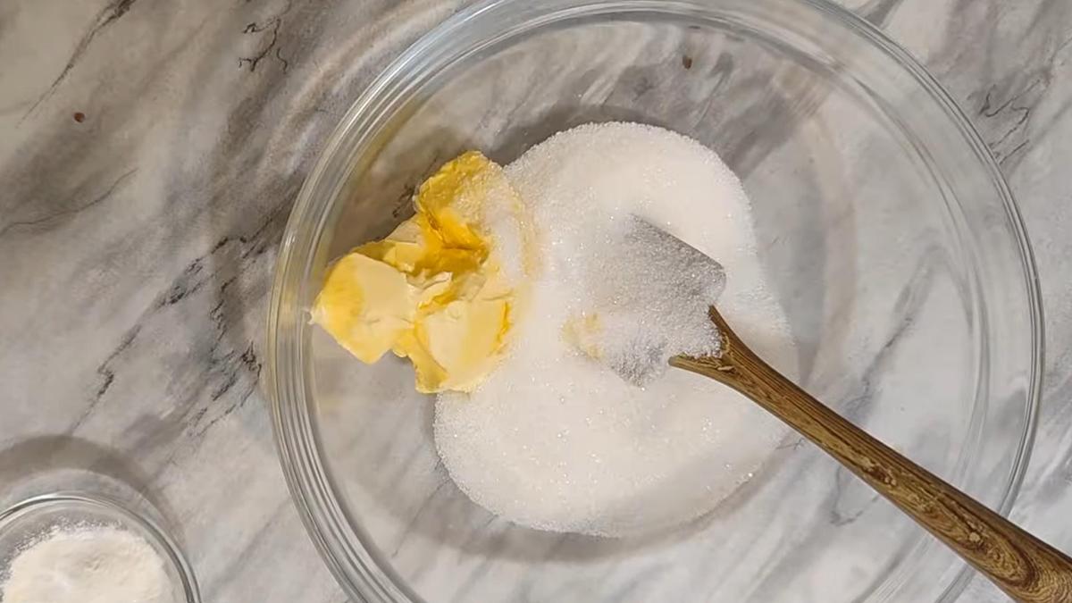 В стеклянной миске мягкое сливочное масло и сахар