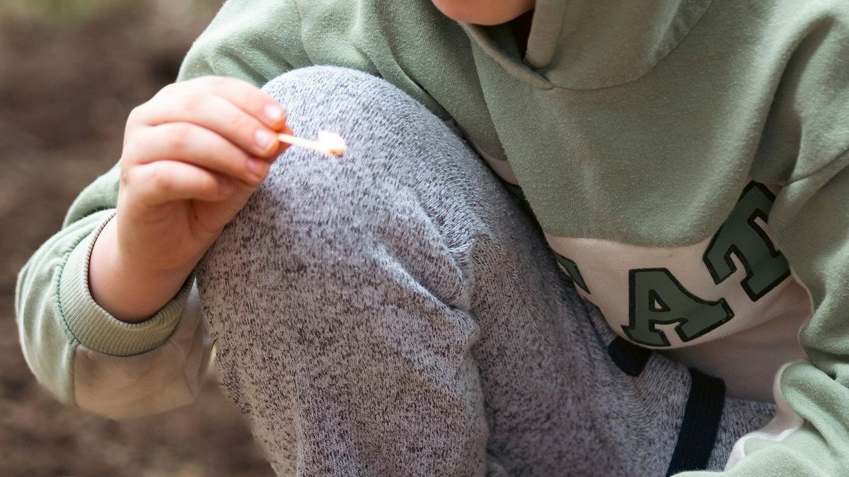 Мальчик держит спичку