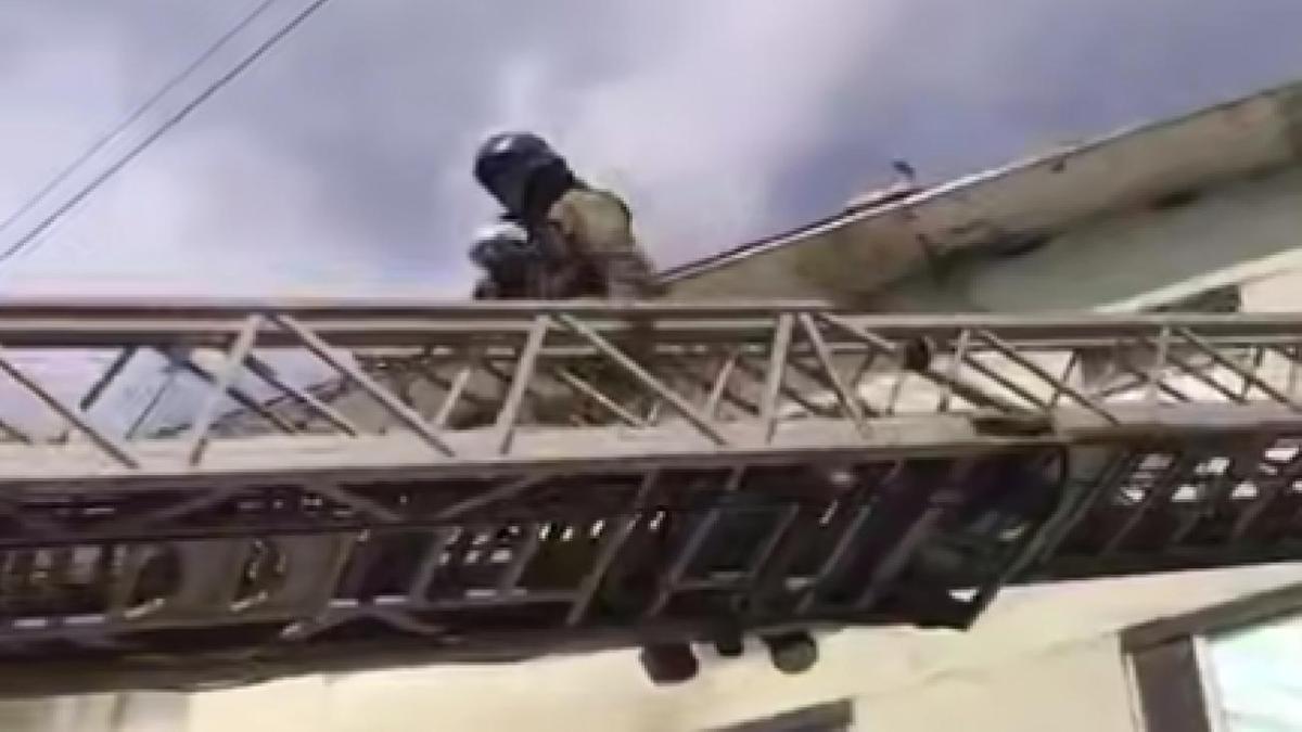Пожарный эвакуирует ребенка по автолестнице Пожарный эвакуирует ребенка по автолестнице