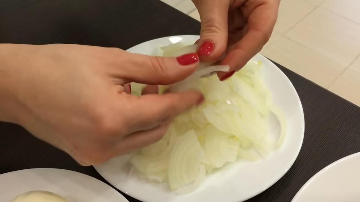 Лук в руках нарезанный на полукольца