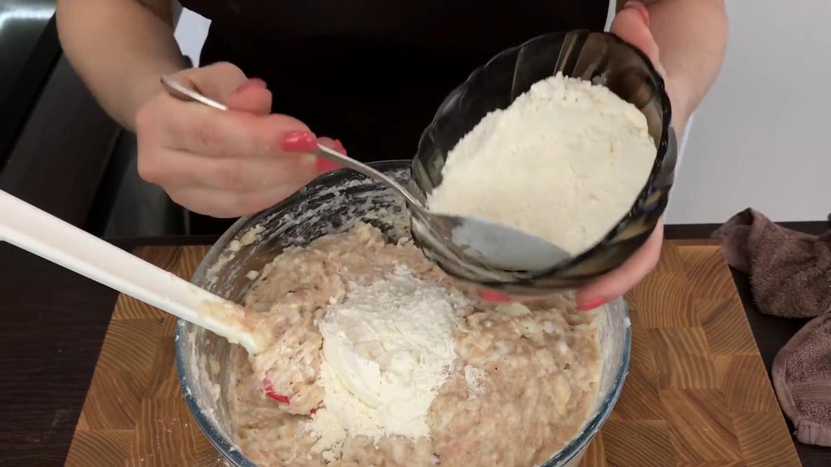 В миску с фаршем ложкой насыпают муку