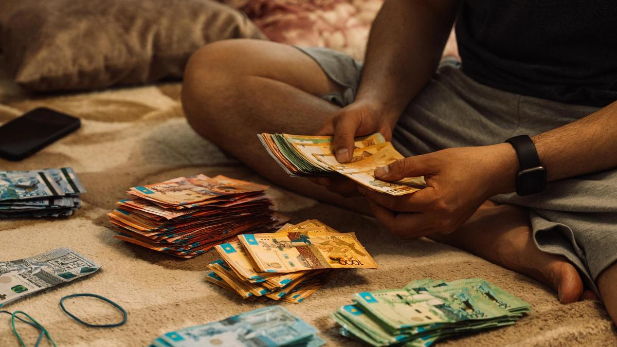 Пачки денег возле мужчины