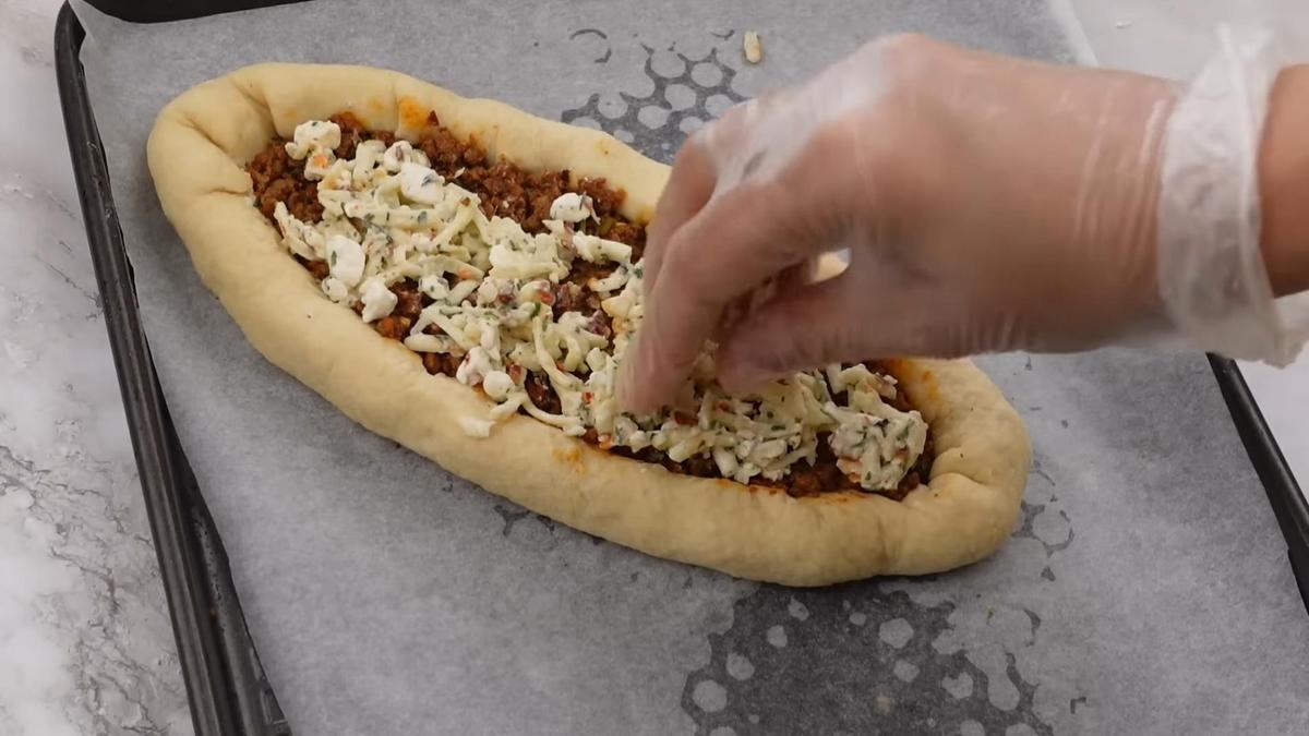 На слой фарша выкладывают сырную начинку