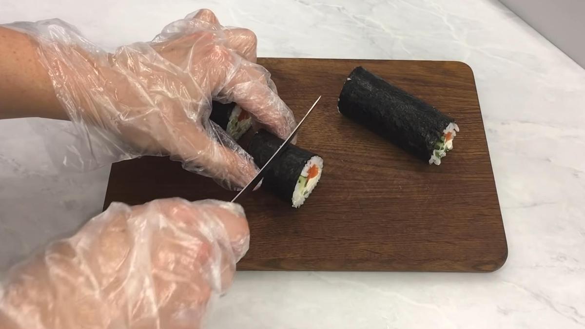 Ролл нарезают на разделочной доске