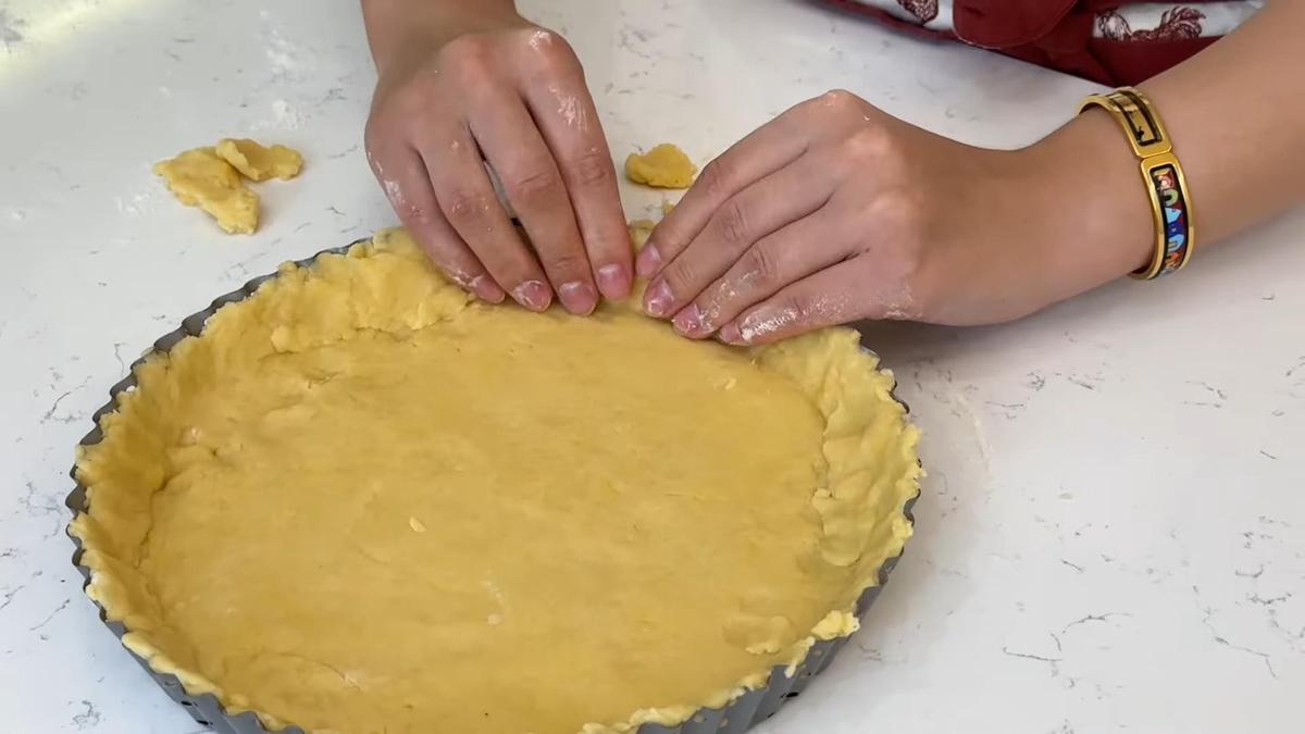 В форме для выпечки выкладывают основу для пирога из песочного теста