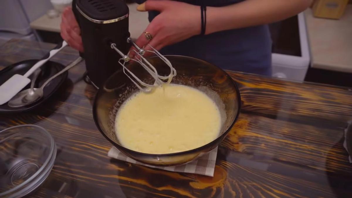 На столе миска со взбитыми с сахаром яйцами. Рядом миксер