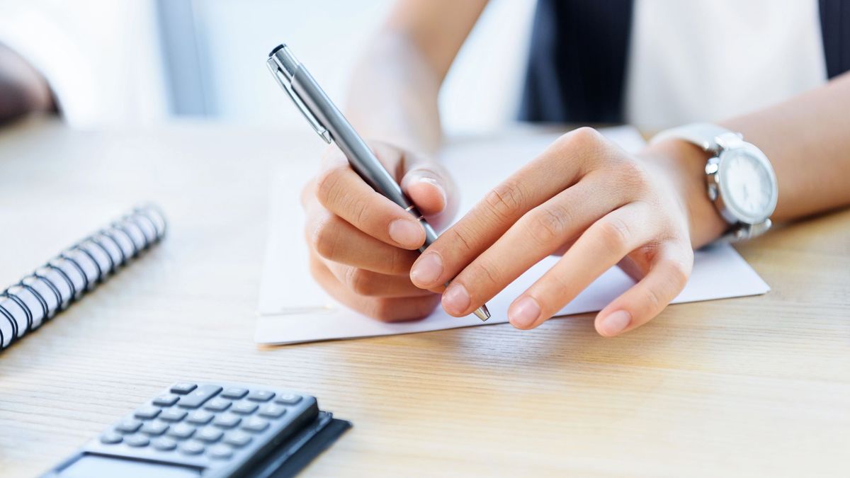 Женщина держит ручку над документом