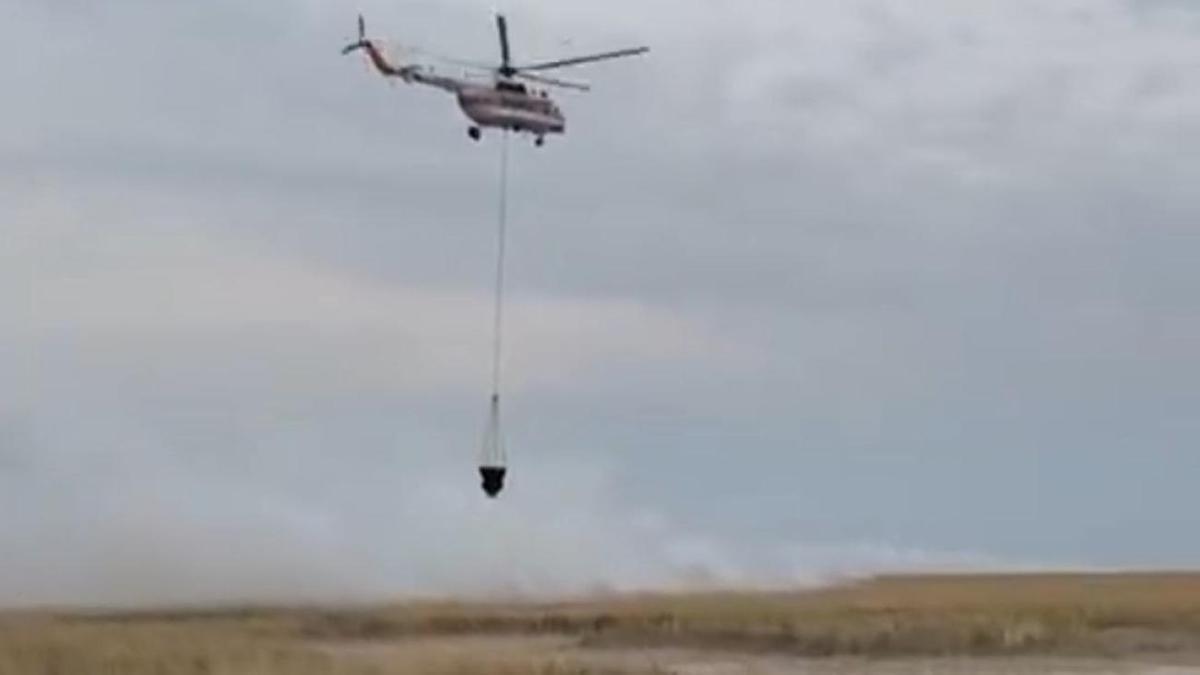 С вертолета тушат горение камыша С вертолета тушат горение камыша