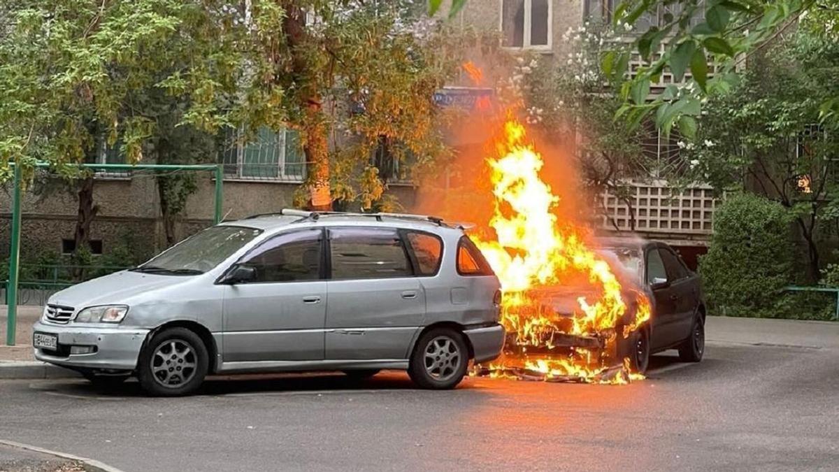 Горящая машина во дворе дома