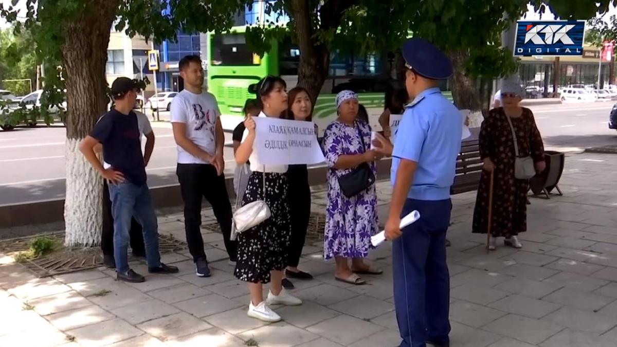 Потерпевшие с плакатами и полицейский