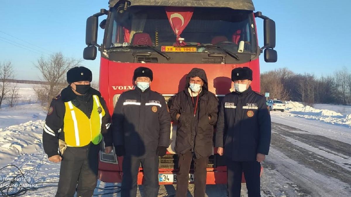 Полицейские и дальнобойщик стоят у грузового авто