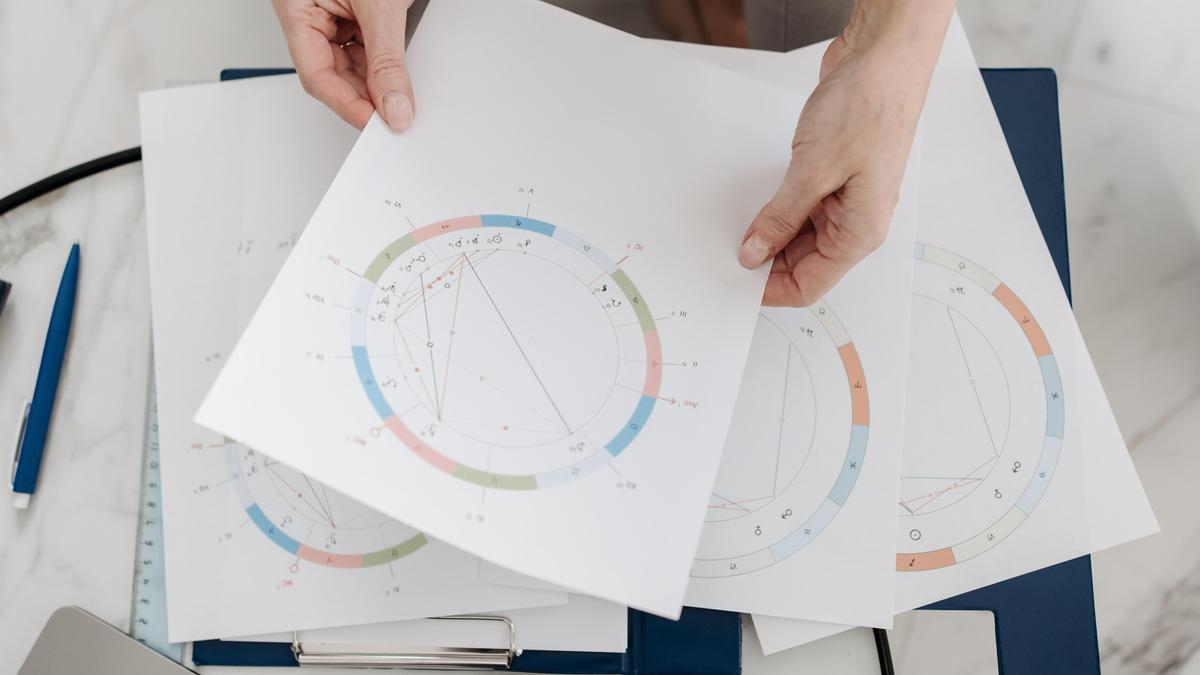 Женщина держит в руках изображение натальной карты