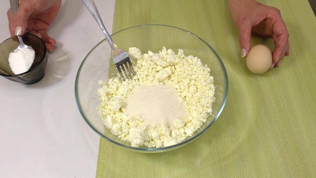Творог смешивают с сахаром в стеклянной миске