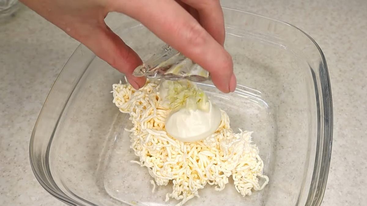Соединяют тертый плавленый сыр с чесноком и майонезом