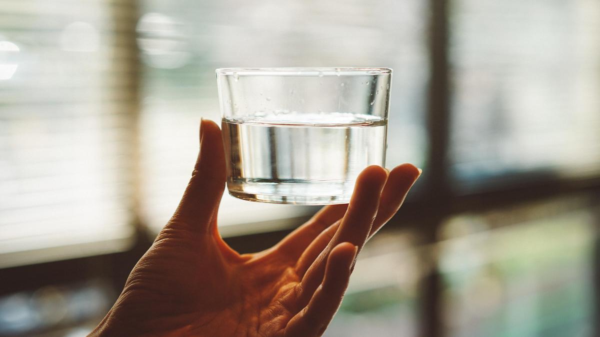 Женская рука держит стакан с водой