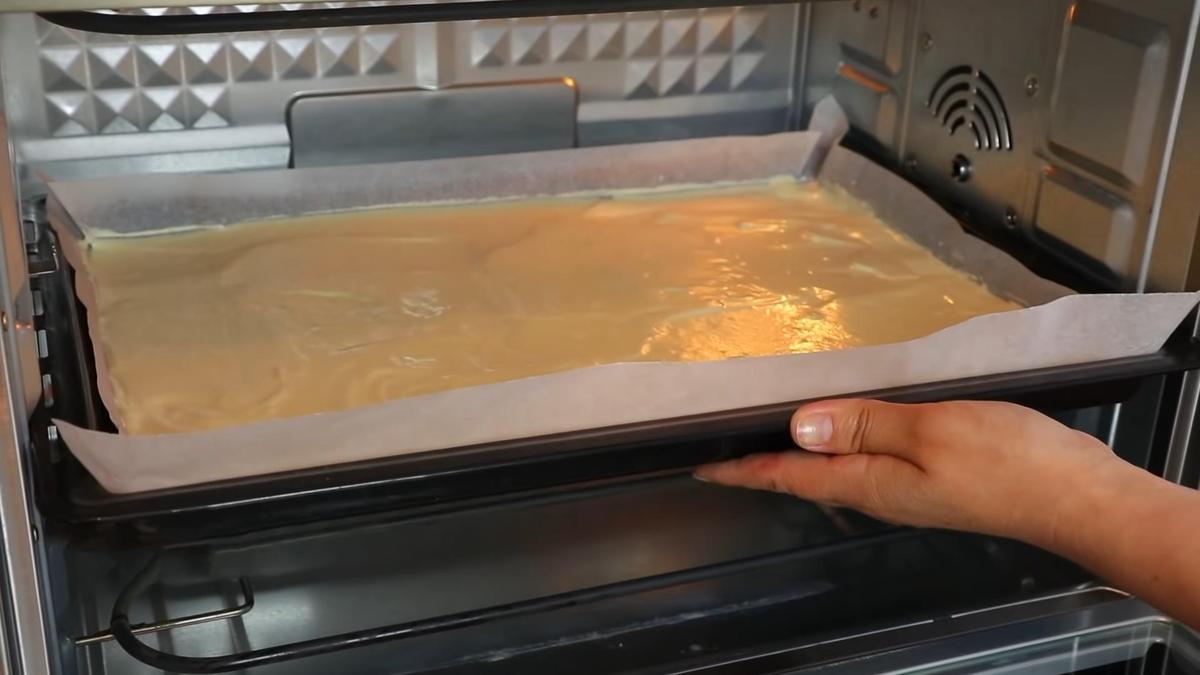 Противень с бисквитным тестом в духовке