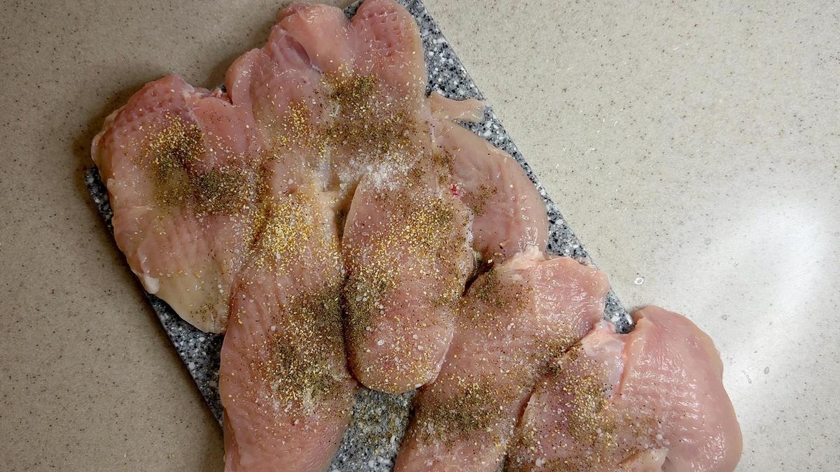 На разделочной доске куриное филе в специях