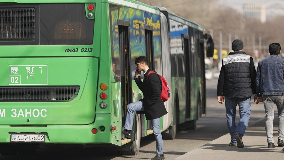 Парень входит в автобус на остановке