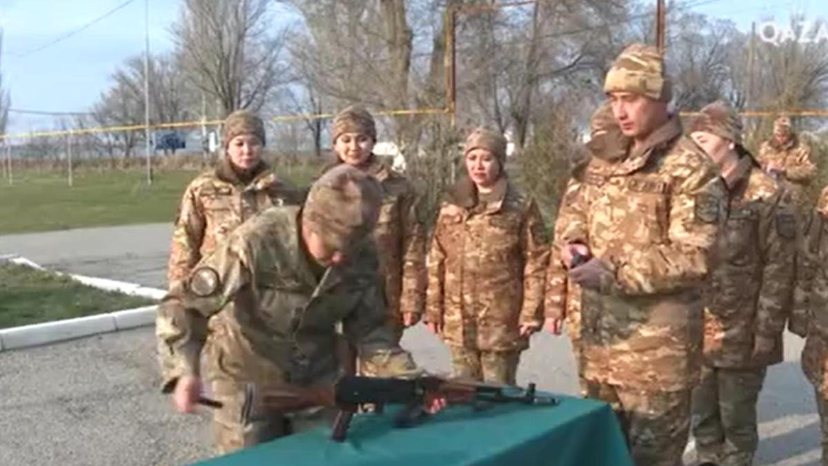 Жауынгер қыз қаруды шашып жинауда Жауынгер қыз қаруды шашып жинауда