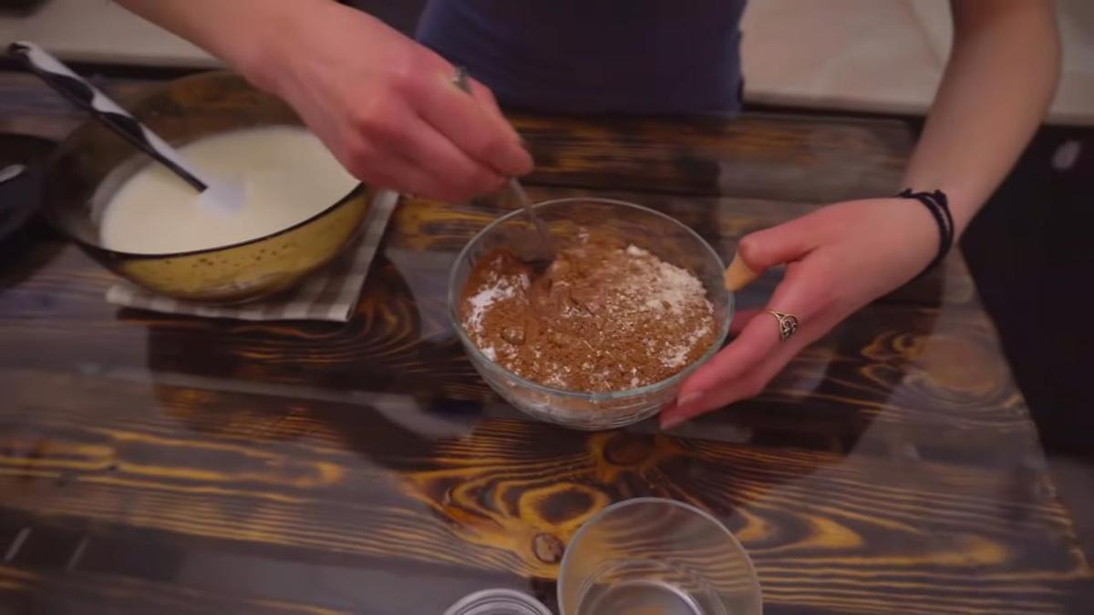 Девушка смешивает в стеклянной пиале муку с какао