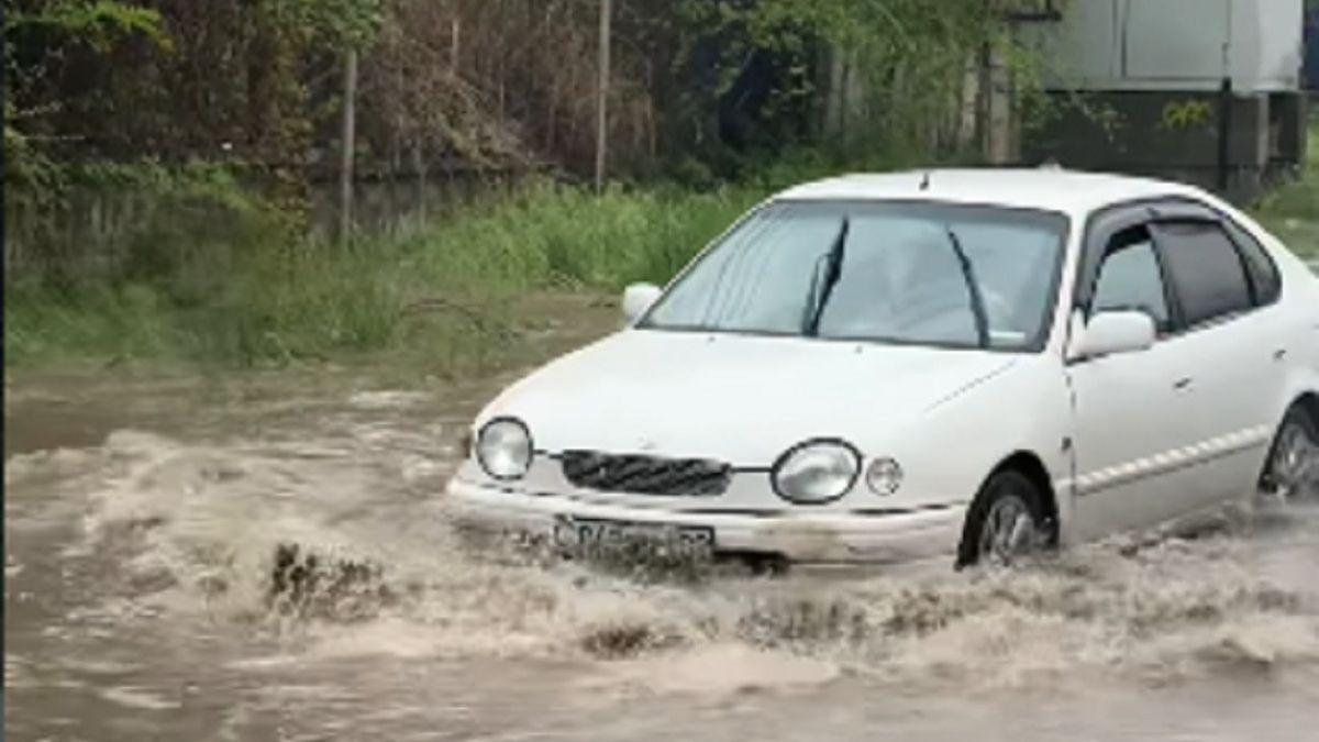 Машина едет по подтопленной улице