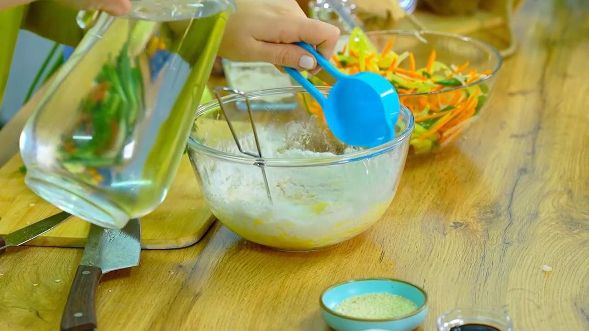 В миску с мукой мерной ложкой наливают воду