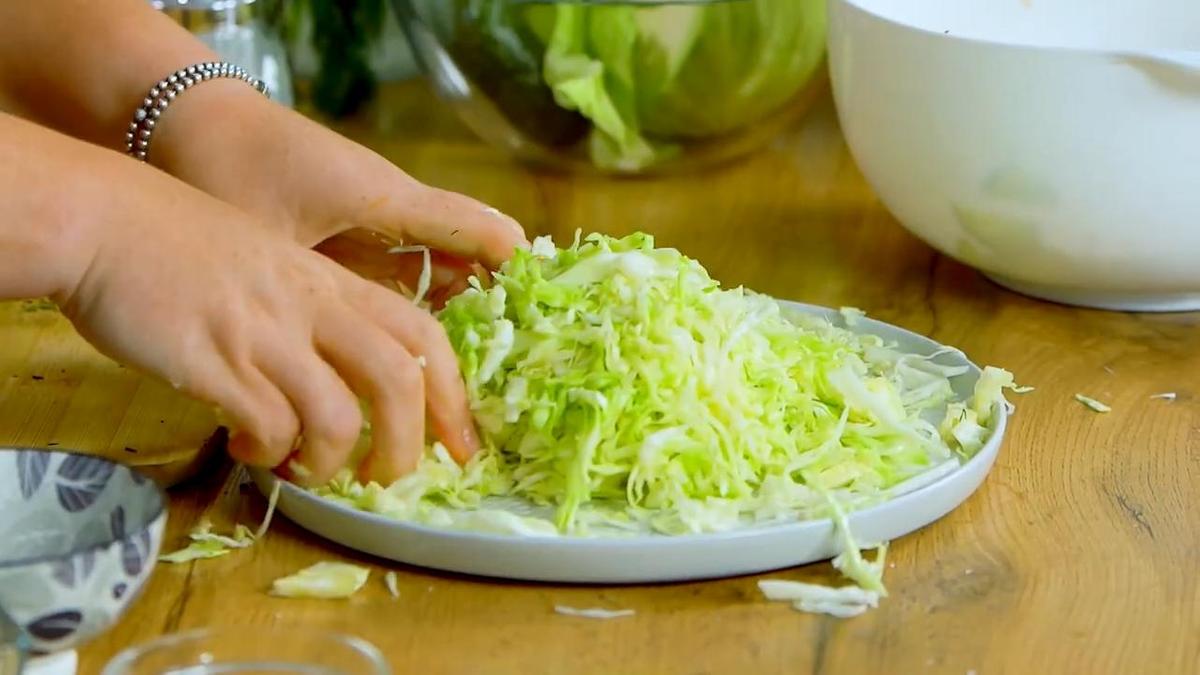 Женские руки перемешивают нарезанную капусту