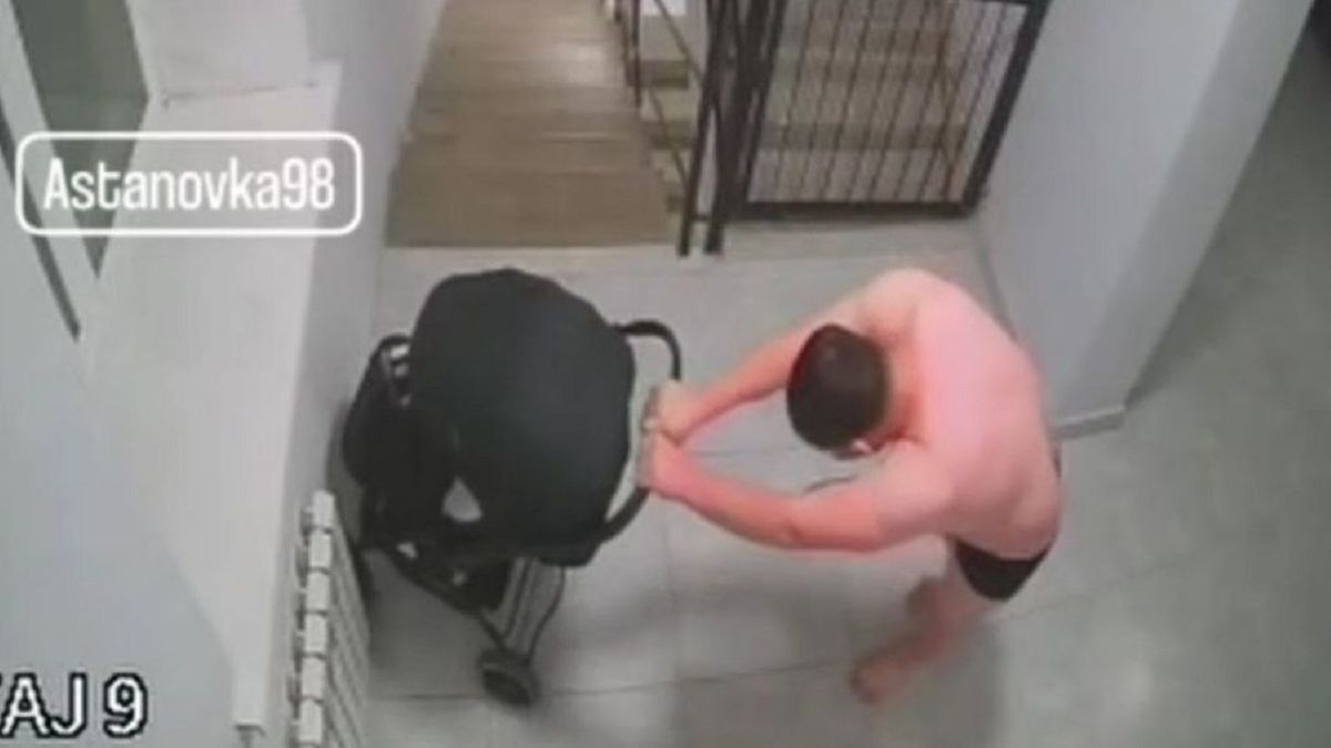 Мужчина с коляской в подъезде