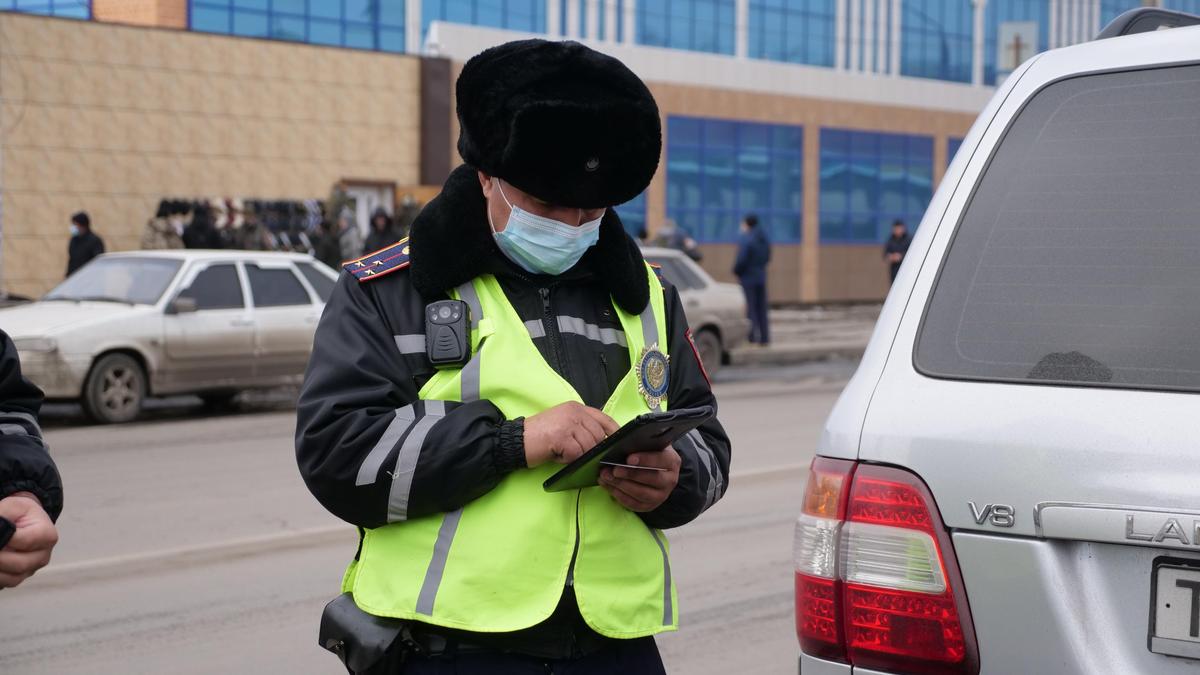 Полицейские проверяет номер авто в планшете