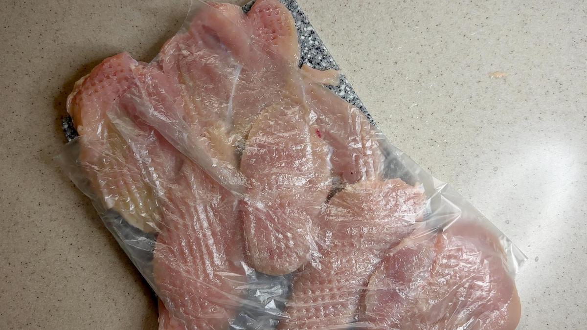 На разделочной доске отбитое куриное филе