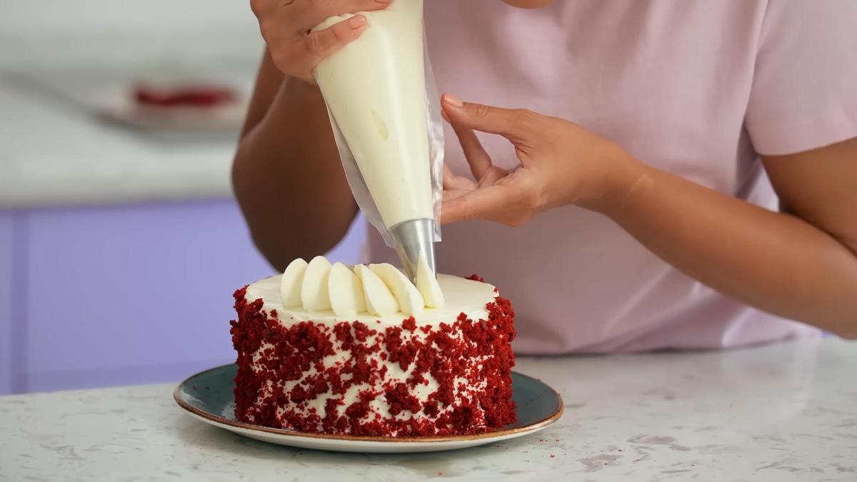 На верхушку торта отсаживают крем из кондитерского мешка