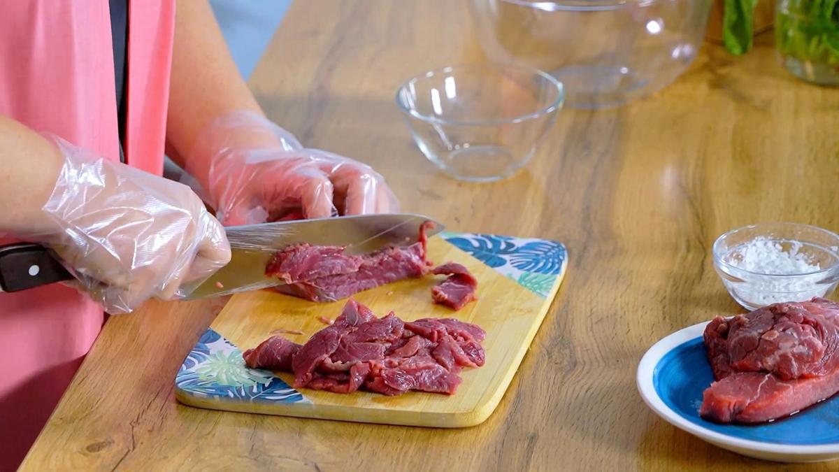 Мякоть говядины нарезают на разделочной доске
