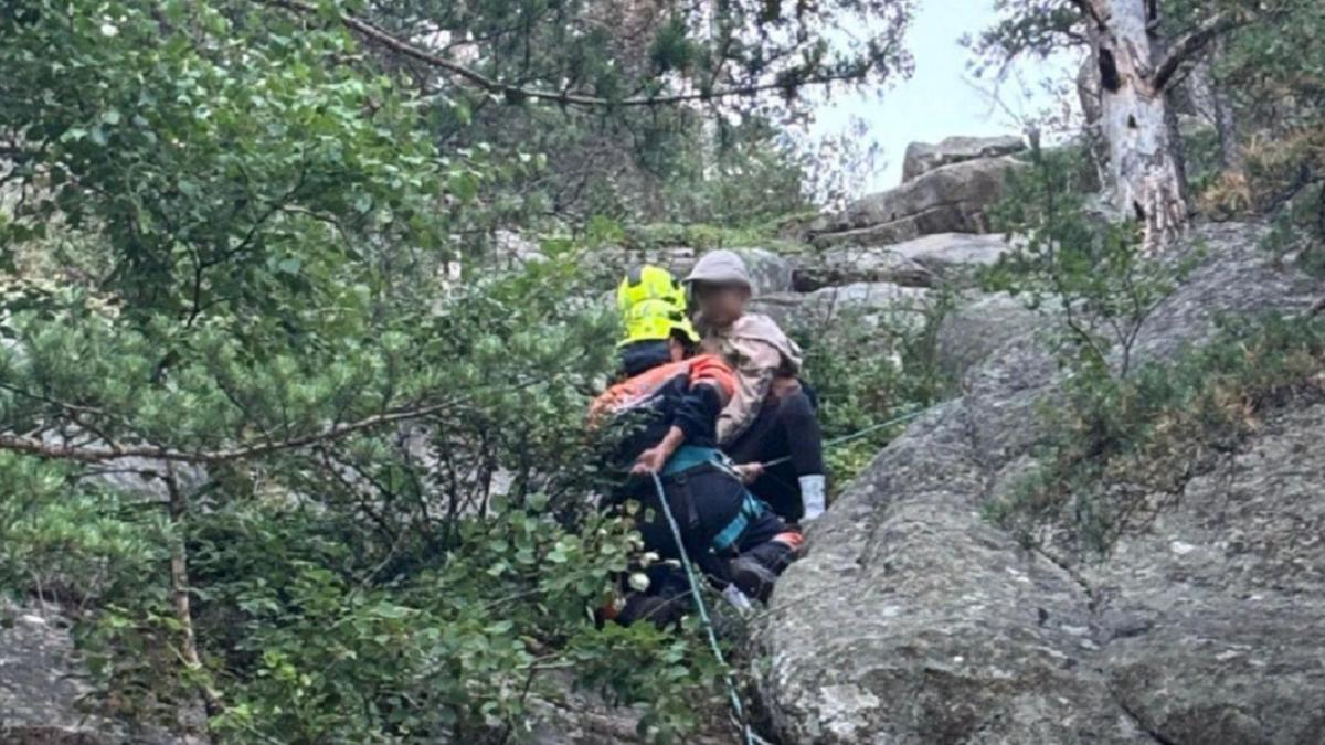 Спасатель спускается на веревке с ребенком