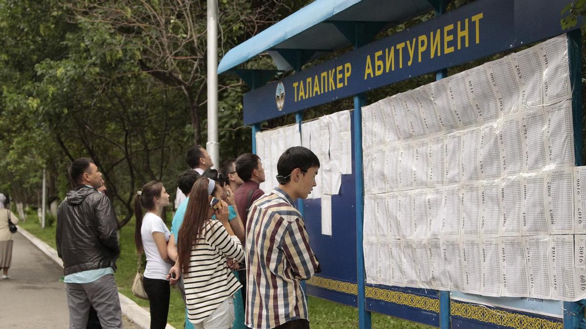 Выпускники смотрят результаты на стенде