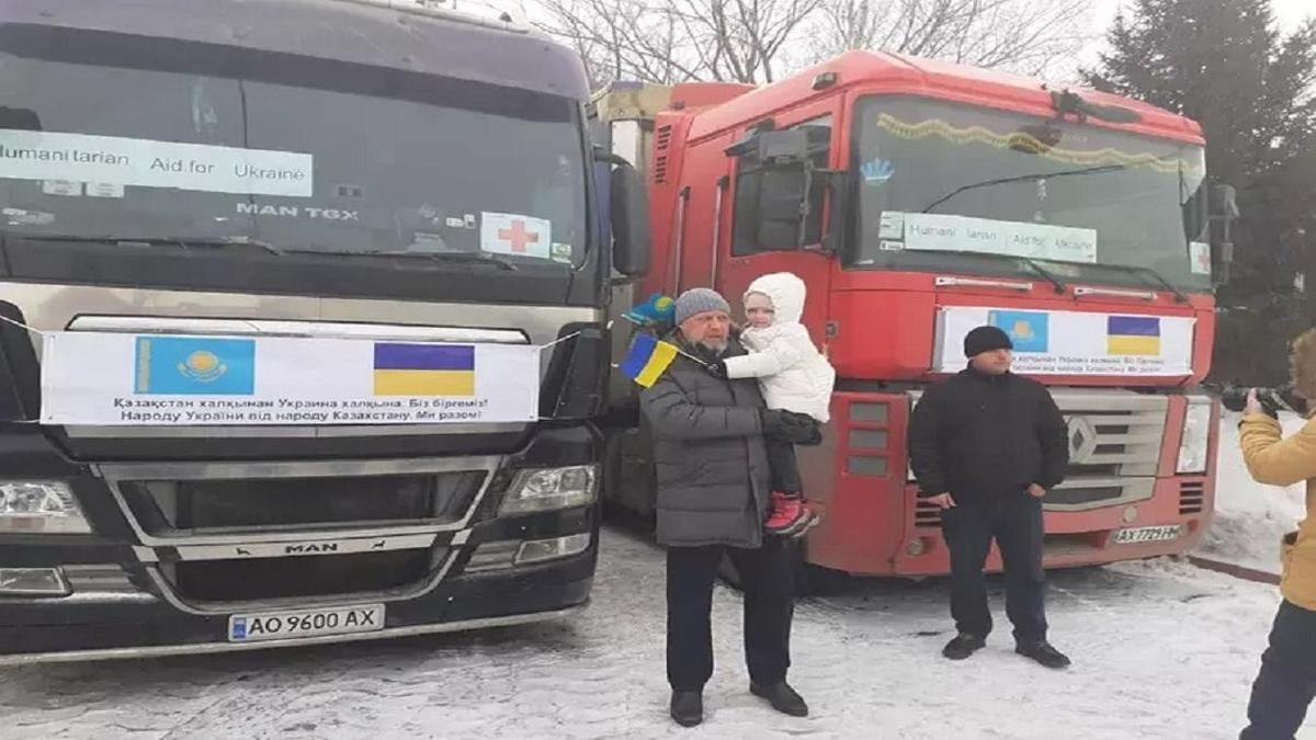 Петр Врублевский жүк тиелген екі көлік жанында