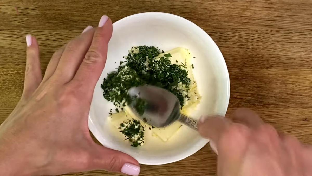 В пиале перемешивают сливочное масло, нарезанные чеснок, укроп и петрушку