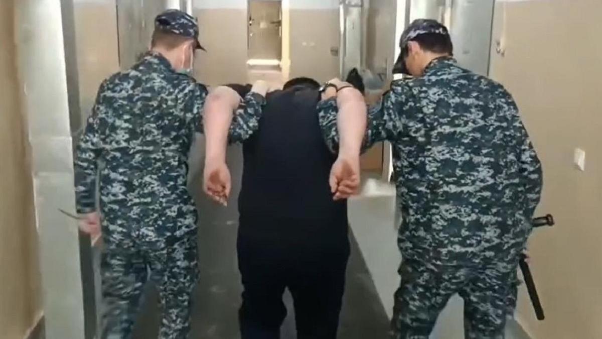 полиция қызметкерлері күдіктіні алып кетіп бара жатыр полиция қызметкерлері күдіктіні алып кетіп бара жатыр