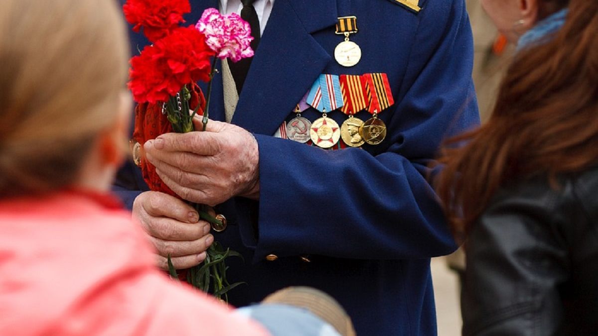 Ветеран держит в руках гвоздики