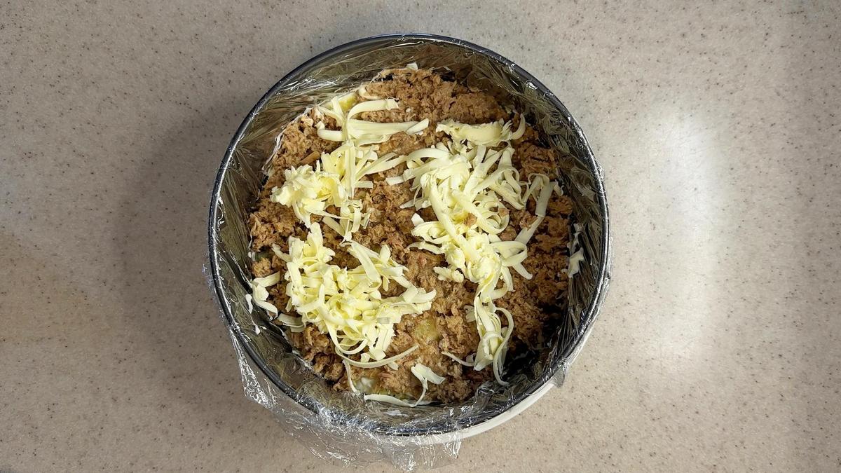 В формовочном кольце рыбные консервы из тунца и сливочное масло