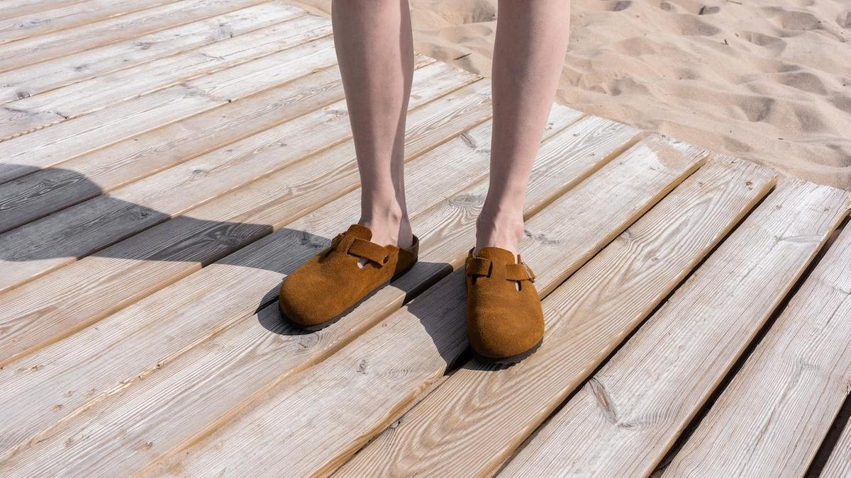 Человек стоит в обуви Birkenstock на пляже