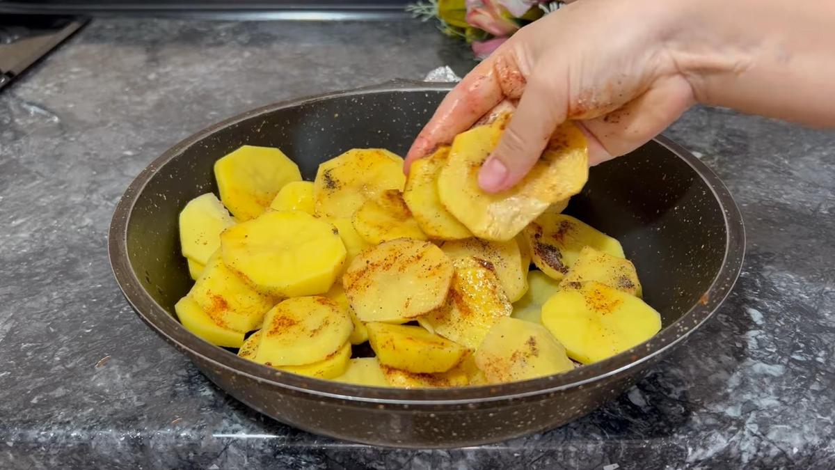 В сковороде картофель, нарезанный слайсами, в масле и специях