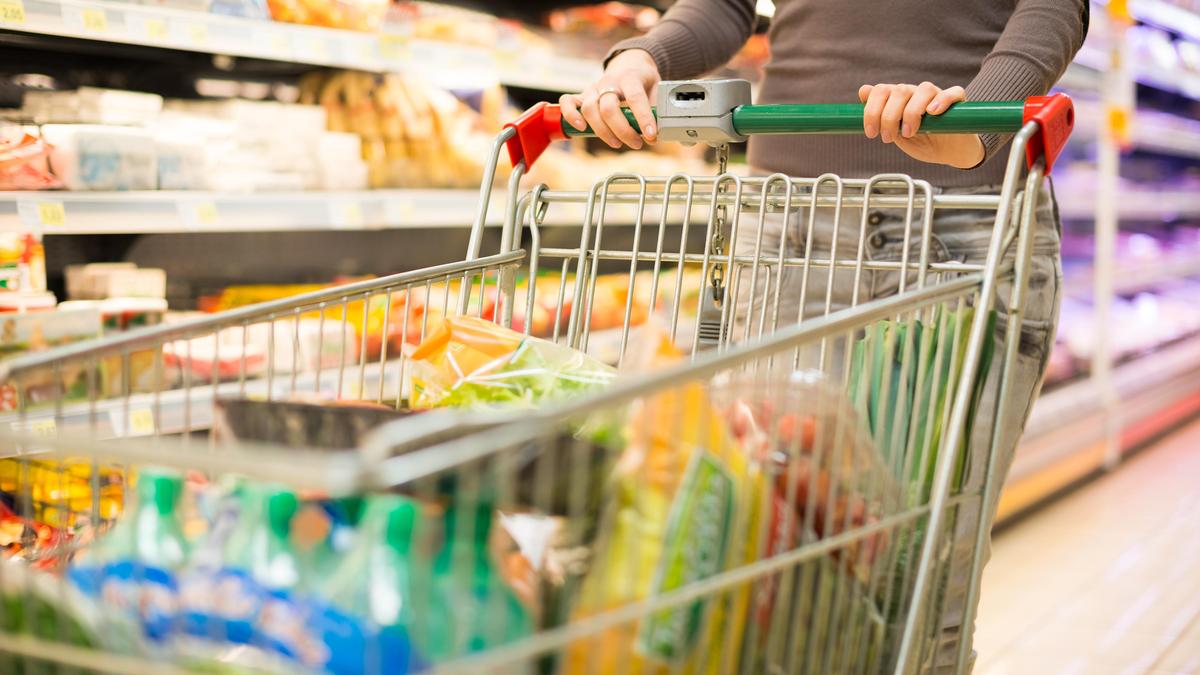 Женщина покупает продукты в супермаркете