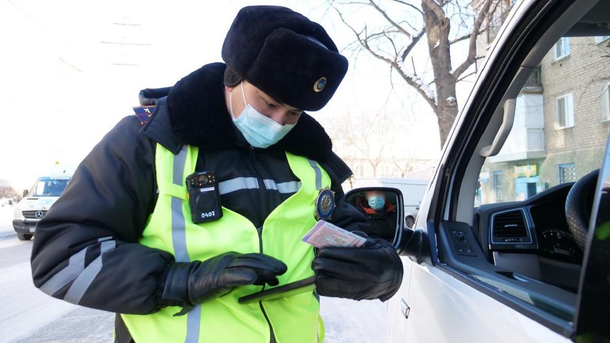 полицейский проверяет документы у водителя