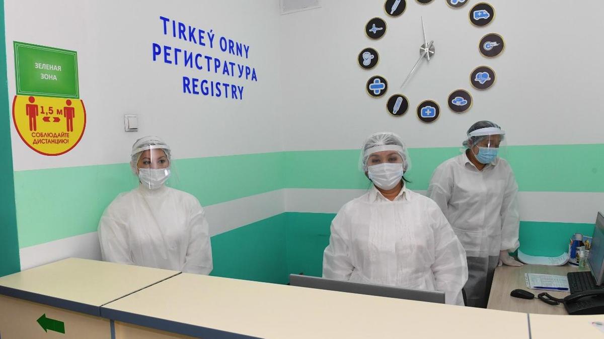 Медработники стоят у стойки регистратуры Медработники стоят у стойки регистратуры